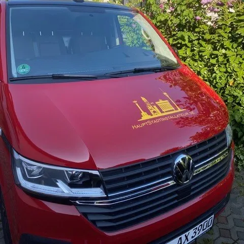 Roter VW Transporter der KlaTes GmbH mit dem gelben Logo auf der Motorhaube.