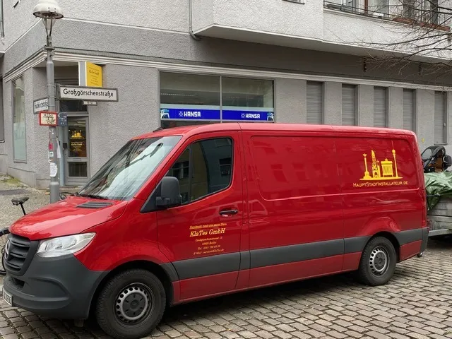 Ein roter Sprinter der KlaTes GmbH vor dem Betrieb in der Großgörschenstraße, im Hintergrund das Straßenschild.